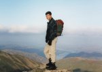 Photograph of a male hiker standing on top of Helvellyn, a mountain in the English Lake District