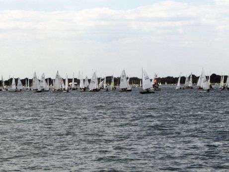 Photograph of small sailing dinghies racing just off shore