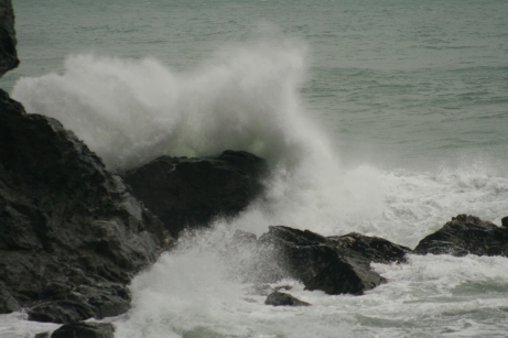 Photograph of a destructive wave breaking on the base of a cliff